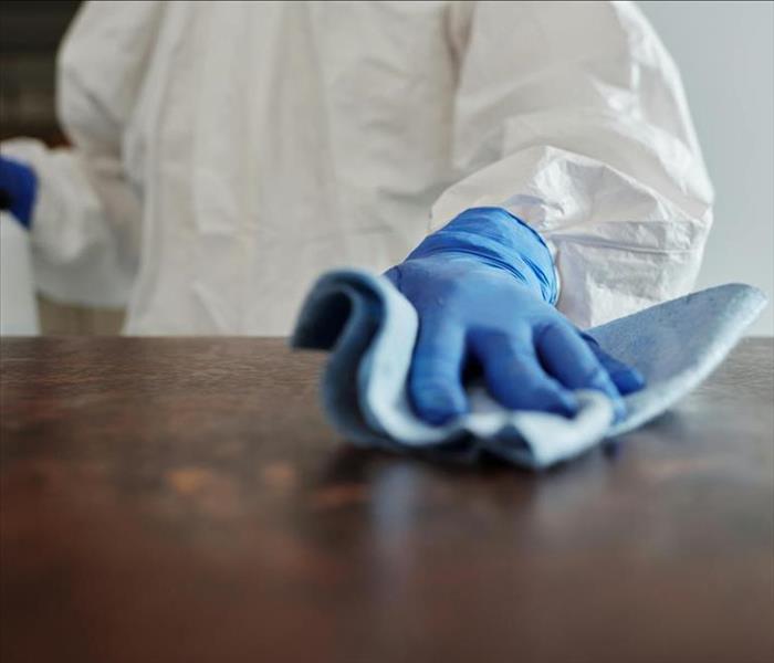 An image of a person cleaning a table surface